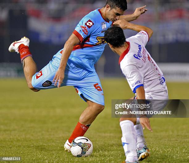 Argentinian Arsenal's players Ivan Marcone vies for the ball with Paraguay's Nacional's player Julian Benitez during their Copa Libertadores football...