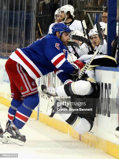Dan Girardi of the New York Rangers checks Chris Kunitz of the Pittsburgh Penguins into the boards during Game Four of the Second Round in the 2014...