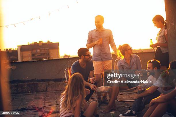 casual party on the roof - sunset city stock pictures, royalty-free photos & images