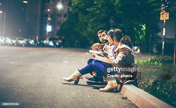 people eating pizza in the street. - eating street food stock pictures, royalty-free photos & images