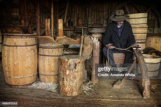 Candid, interior image of a man at work in a Cooperage. A cooperage is place where barrels were/are made to store all manner of items including...