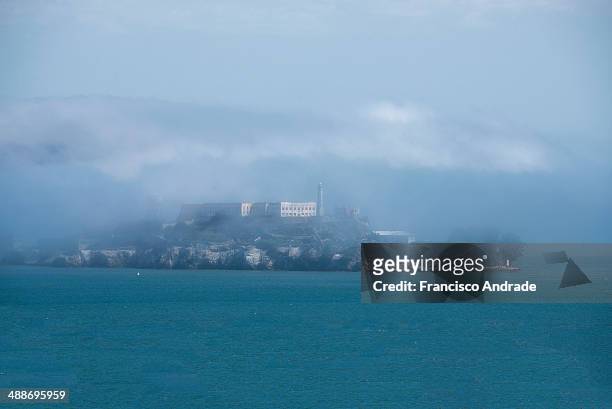 Ilha de Alcatraz em San Francisco envolta sob intenso nevoeiro. Alcatraz Island in San Francisco shrouded in dense fog.