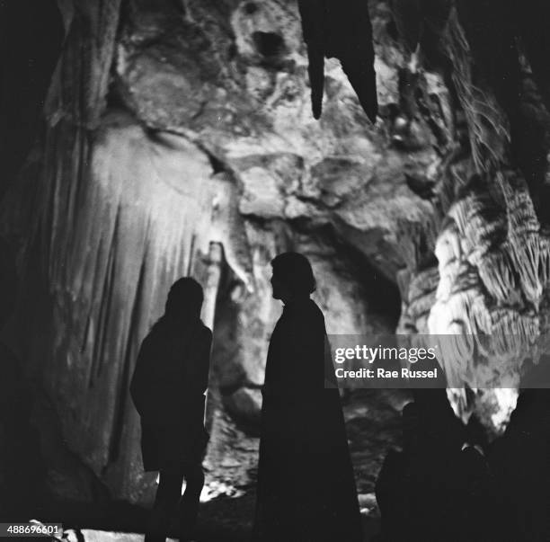 Stark silhouettes of visitors stand against illuminated stalactites in the Luray Caverns, Luray, Virginia, 1949.
