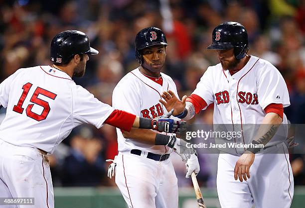 Jonny Gomes of the Boston Red Sox is congratulated by teammates Jonathan Herrera and Dustin Pedroia after scoring the go-ahead run in the 8th inning...