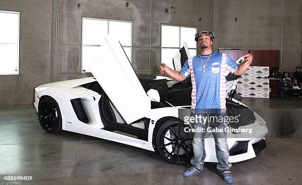 National Football League player Marshawn Lynch poses in front of his 2013 Lamborghini Aventador Roadster, equipped with Monster Sound, at Findlay...