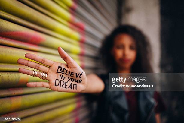 afroamerikanische mädchen mit inspirierenden meassage schriftliche auf ihre hand - african american girl look up stock-fotos und bilder