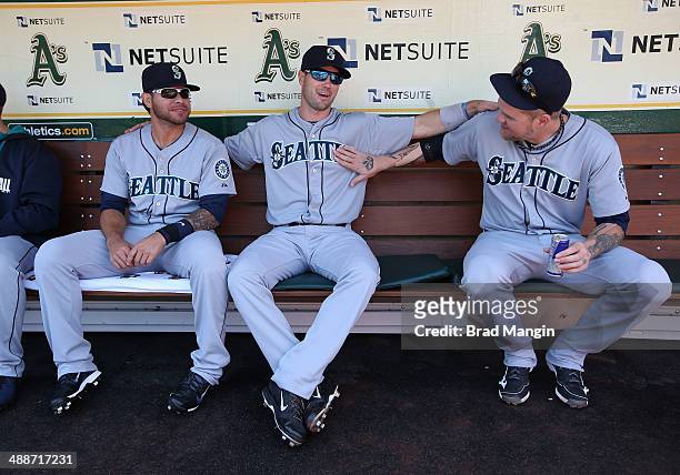 Stefen Romero, Cole Gillespie, and Corey Hart of the Seattle Mariners laugh in the dugout before game one of a doubleheader against the Oakland...