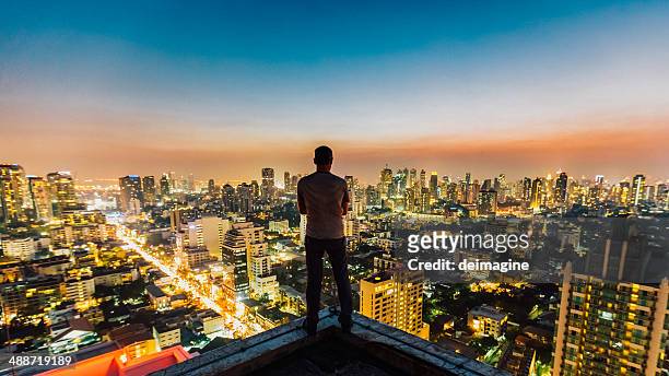 man on top of skyscraper - bangkok people stock pictures, royalty-free photos & images