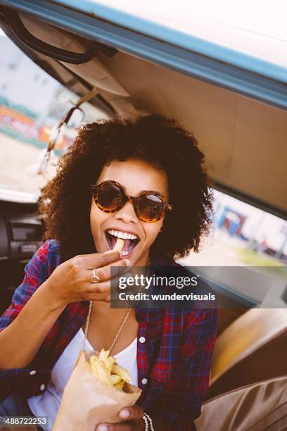 girl is eating french fries - eating in car stock pictures, royalty-free photos & images