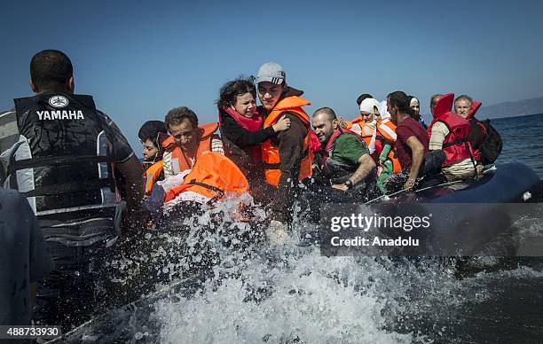 Refugees get off the boat after it arrived in Lesbos Island, Greece on September 17, 2015. Refugees who begin a journey with a hope to have high...