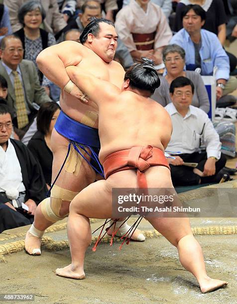 Yoshikaze pushes ozeki Kotoshogiku out of the ring to win during day five of the Grand Sumo Autumn Tournament at Ryogoku Kokugikan on September 17,...