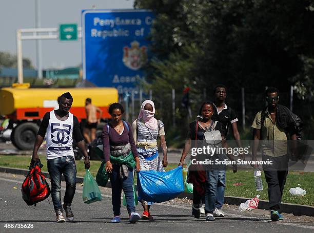 Migrants walk down the motorway toward buses which will take them to Croatia at the Horgos border crossing with Hungary on September 17, 2015 in...