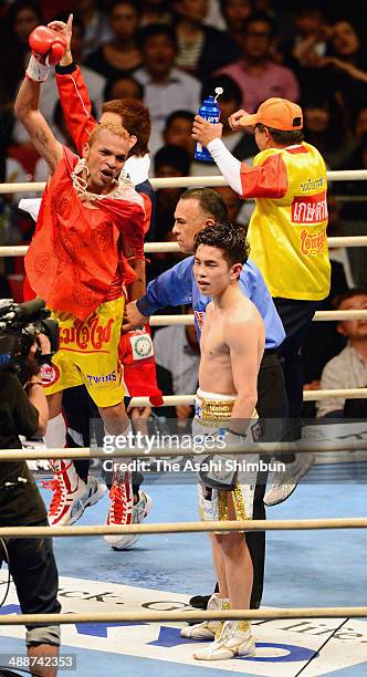 Champion Amnat Ruenroeng of Thailand celebrates defending the title while challenger Kazuto Ioka of Japan shows his dejection after their IBF...