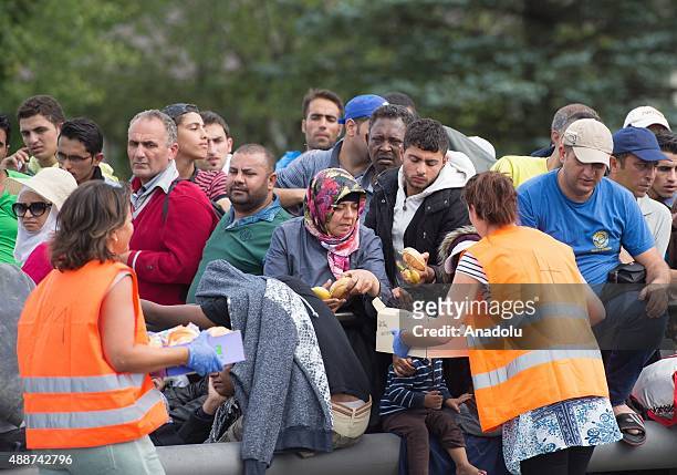 Volunteers hand out food to the refugees on a bridge connecting Austria and Germany on September 17, 2015 in Freilassing, Germany. Hundreds of...