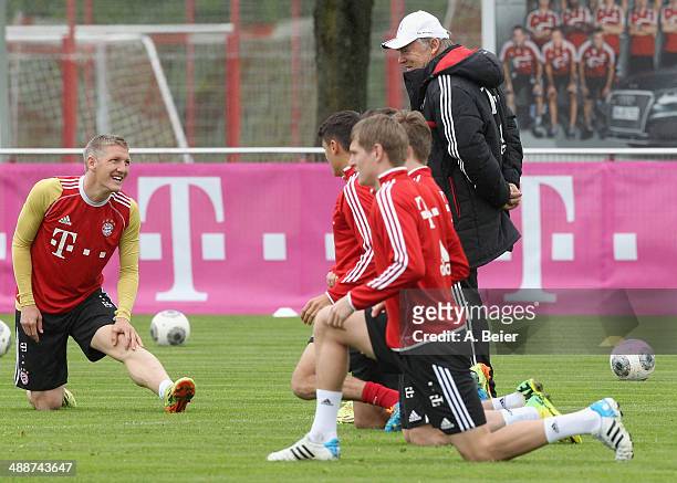 Bastian Schweinsteiger of Bayern Muenchen chats with assistent coach Hermann Gerland as he warms up during a training session at the FC Bayern...