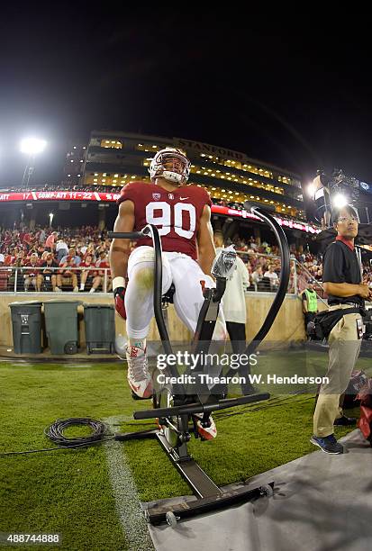 Solomon Thomas of the Stanford Cardinal stays warm by riding a stationary bike on the sidelines against the UCF Knights during an NCAA football game...