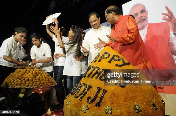 Leader and Tourism Minister Mahesh Sharma along with Bindeshwar Pathak of Sulabh International and school children with a huge 365-kg weighing Laddoo...