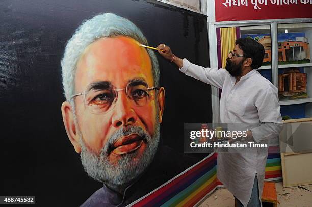 Painter Raj Saini showing the paintings of Prime Minister Narendra Modi on the occasion of his 65th birthday on September 17, 2015 in Bhopal, India....