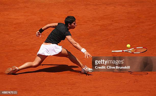 Carla Suarez Navarro of Spain throws her racket at the ball after failing to reach a backhand against Serena Williams of the United States in their...