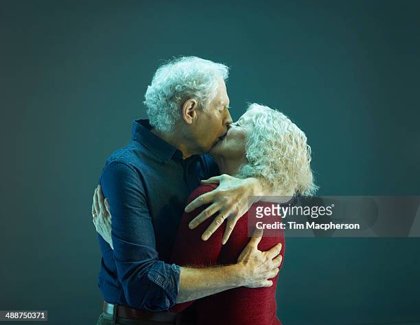 senior couple kissing - senioren koppel studio stockfoto's en -beelden