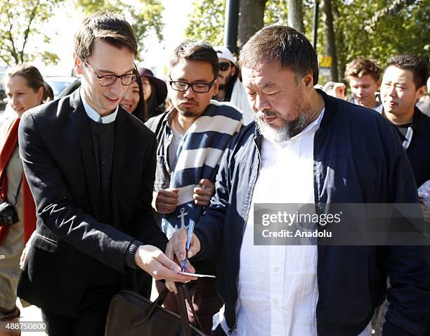 Ai Weiwei autographs as he walks through the city as part of a march in solidarity with migrants currently crossing Europe on September 17, 2015 in...