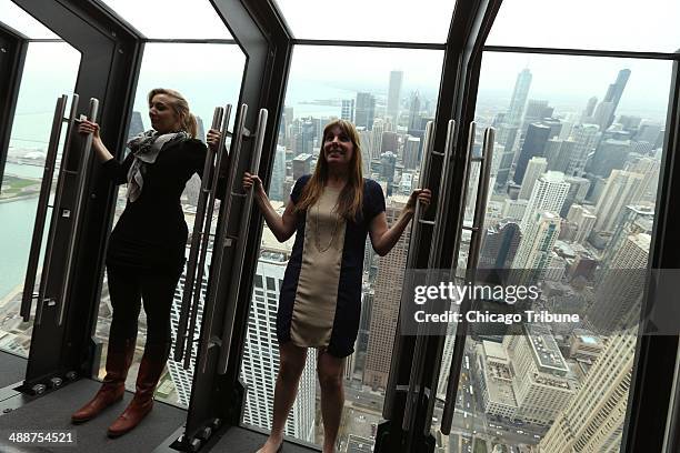 Marketing manager Leslie Cooke, left, and Laura Collins, of Isabelli Media Relations, lean back on a new attraction called "Tilt" which has viewers...