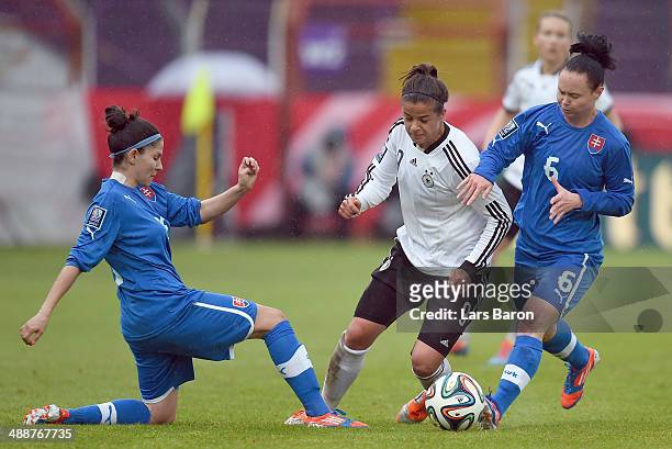 Lena Lotzen of Germany is challenged by Alexandra Biroova and Kristina Cerovska of Slovakia during the FIFA Women's World Cup 2015 Qualifier between...