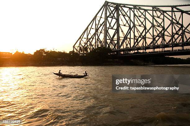 fishermen with the fishing boat on the river - howrah bridge stock pictures, royalty-free photos & images