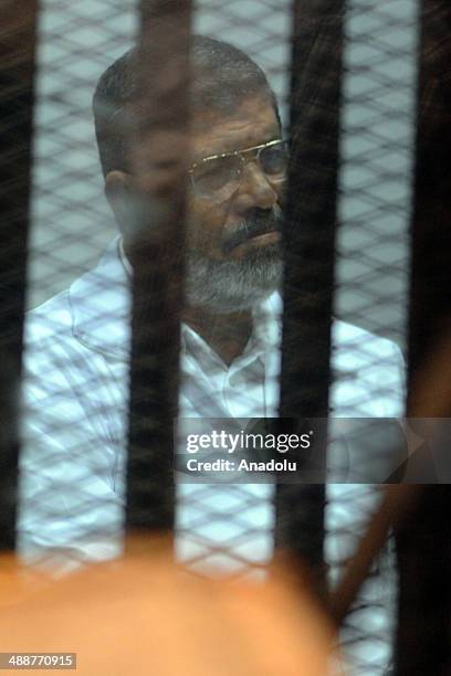 Mohammed Morsi stands inside a defendant's cage during his trial at an eastern Cairo police academy in Cairo, Egypt, on April 30, 2014. An Egyptian...