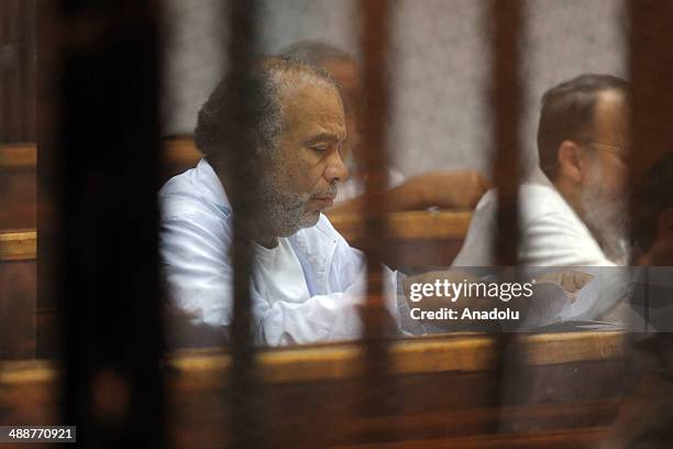 Saad al-Katatni, leader of the Brotherhood's Freedom and Justice Party, stands inside a defendant's cage during his trial at an eastern Cairo police...