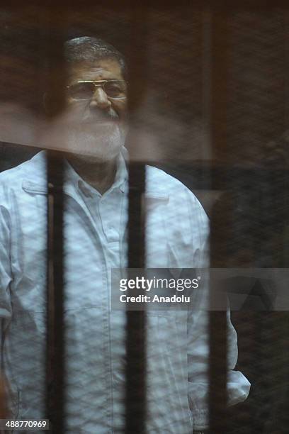 Mohammed Morsi stands inside a defendant's cage during his trial at an eastern Cairo police academy in Cairo, Egypt, on April 30, 2014. An Egyptian...