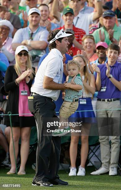 Bubba Watson of the United States celebrates with his son Caleb on the 18th green after winning the 2014 Masters Tournament by a three-stroke margin...