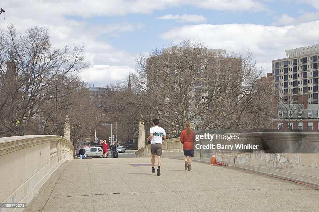 Joggers on footbridge over Charles River