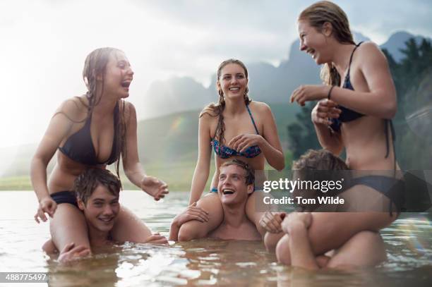 three girls sitting on their boyfriend's shoulders - adolescent africain photos et images de collection