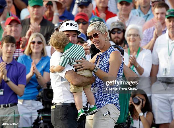 Bubba Watson of the United States celebrates with his wife Angie and their son Caleb on the 18th green after winning the 2014 Masters Tournament by a...