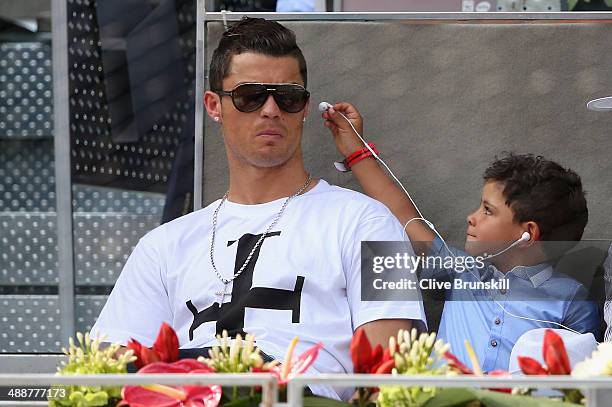 Real Madrid footballer Cristiano Ronaldo and his son Cristiano Ronaldo Junior watch Rafael Nadal of Spain against Jarkko Nieminen of Finland in their...