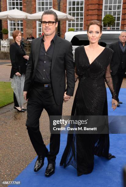 Brad Pitt and Angelina Jolie arrive at a private reception as costumes and props from Disney's "Maleficent" are exhibited in support of Great Ormond...