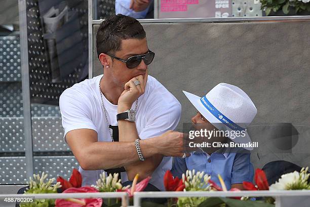 Real Madrid footballer Cristiano Ronaldo and his son Cristiano Ronaldo Junior watch Rafael Nadal of Spain against Jarkko Nieminen of Finland in their...