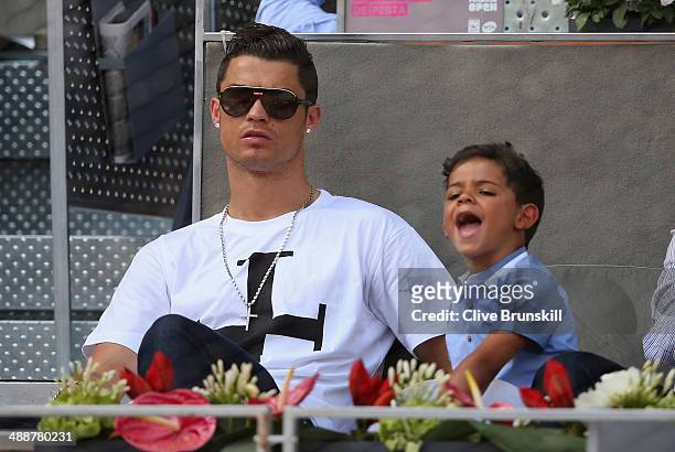 Real Madrid footballer Cristiano Ronaldo and his son Cristiano Ronaldo Junior watch Rafael Nadal of Spain against Jarkko Nieminen of Finland in their...