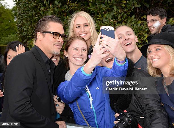 Brad Pitt signs autographs at a private reception as costumes and props from Disney's "Maleficent" are exhibited in support of Great Ormond Street...