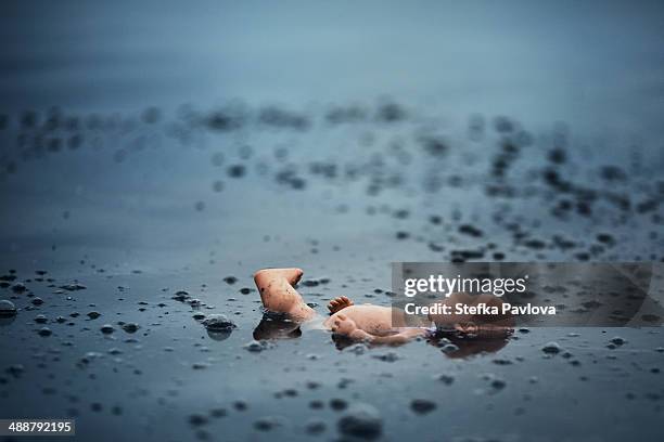 broken baby doll floating in the water - floating on water stock pictures, royalty-free photos & images