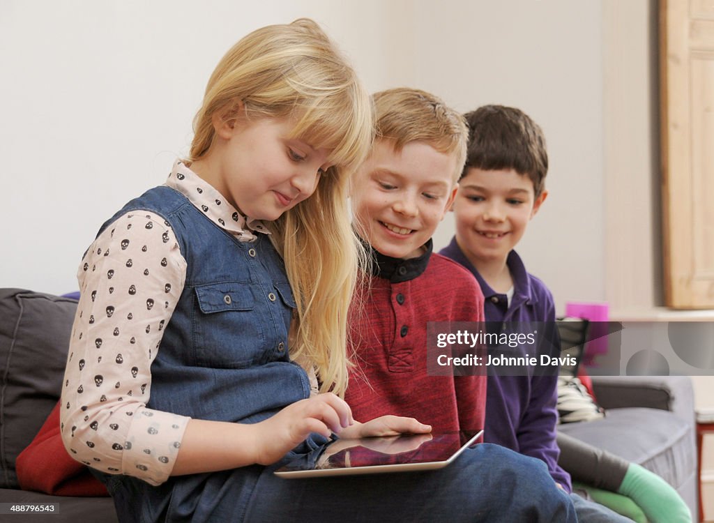 Three children looking at an tablet computer