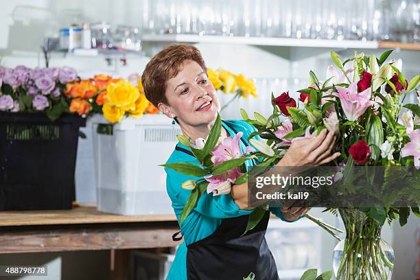 fiorista organizzare il bouquet di fiori in vaso - arranging flowers foto e immagini stock