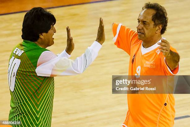 Evo Morales, President of Bolivia and Daniel Scioli Governor of Buenos Aires, greet during a Copa Juana Azurduy match at Villa La Ñata Stadium as...