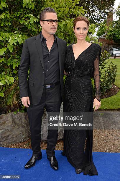 Brad Pitt and Angelina Jolie arrive at a private reception as costumes and props from Disney's "Maleficent" are exhibited in support of Great Ormond...