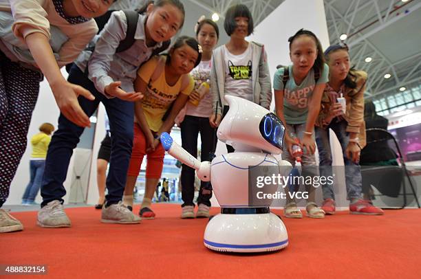 People crowd to watch a robot dancing "Little Apple" on the 3rd China Science & Technology City International High-tech Expo on September 17, 2015 in...