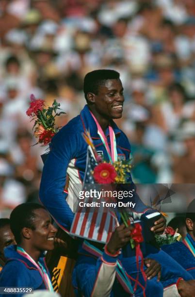 American athlete Carl Lewis is carried on the shoulders of his teammates after his team won the Men's 4 x 100 metres relay at the Los Angeles...