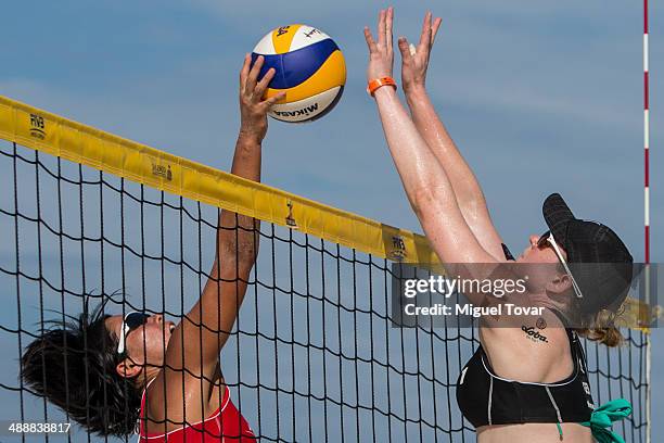 Lulie Sude of Germany fights for the ball with Ayumi Kusano of Japan during a qualification match as part of the 2014 FIVB Beach Volleyball World...