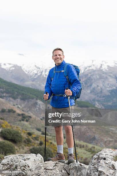 smiling man standing with trekking poles - hiking pole stock pictures, royalty-free photos & images