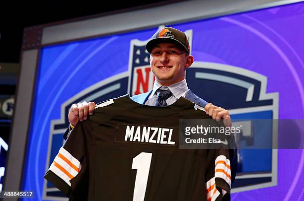 Johnny Manziel of the Texas A&M Aggies poses with a jersey after he was picked overall by the Cleveland Browns during the first round of the 2014 NFL...